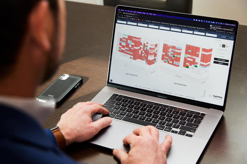 Person working on laptop with Asset Intelligence software interface showing property lease look back information.